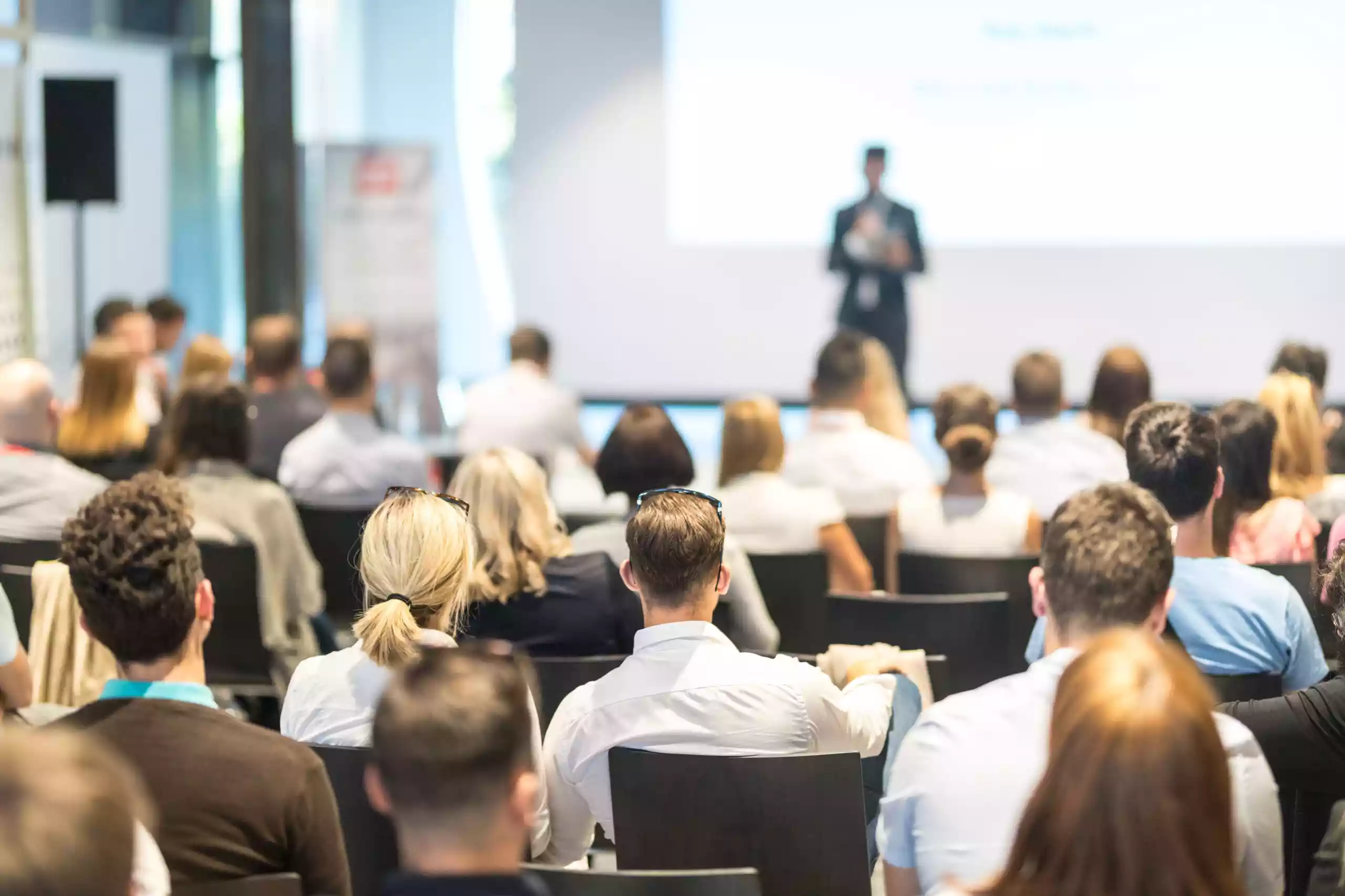 Business speaker giving a talk at business conference event.